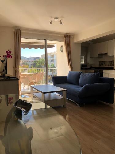 a living room with a blue couch and a table at Edificio Albires in Albir