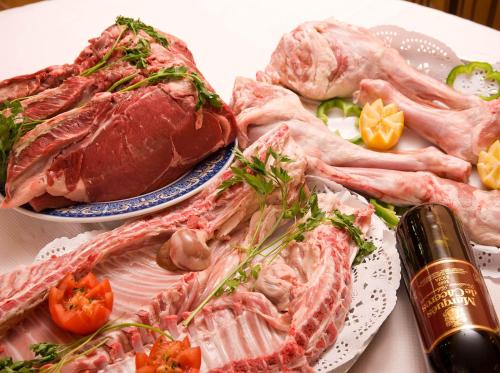 a table with two plates of meat and tomatoes at Hotel Rural "Victoria" in Humanes
