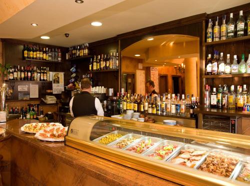 a man standing at a counter in a bar at Hotel Rural "Victoria" in Humanes