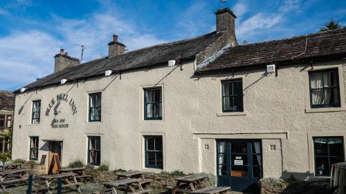 a white building with picnic tables in front of it at The Blue Bell Inn in Kettlewell
