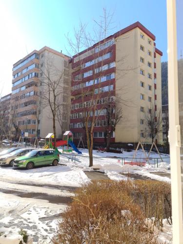 un parking avec des voitures garées devant un bâtiment dans l'établissement ArtStudio, à Braşov