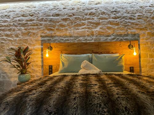 1 dormitorio con 1 cama grande y pared de piedra en Les Jardins Secrets - Gare & Centre by Apparts Spa Dijon en Dijon