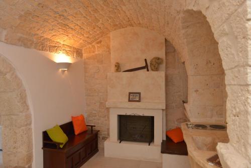 a living room with a fireplace in a stone wall at Masseria Pentima Vetrana Resort in Alberobello