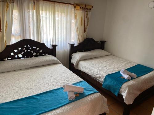 a bedroom with two beds with towels on them at BALCON DE CHIE in Villa de Leyva