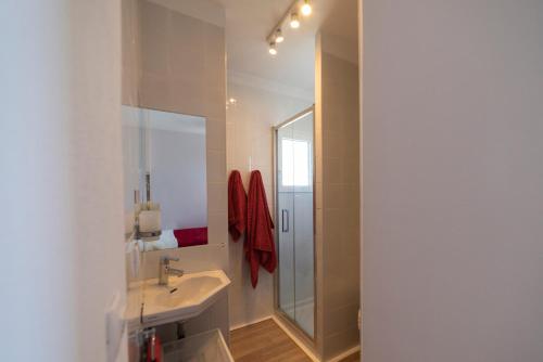 een witte badkamer met een wastafel en een douche bij Apartamento Retiro Sol in Denia