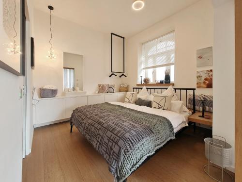 ein Schlafzimmer mit einem großen Bett und einem Fenster in der Unterkunft Luxury Omuntu-Design-Apartment Deluxe in München