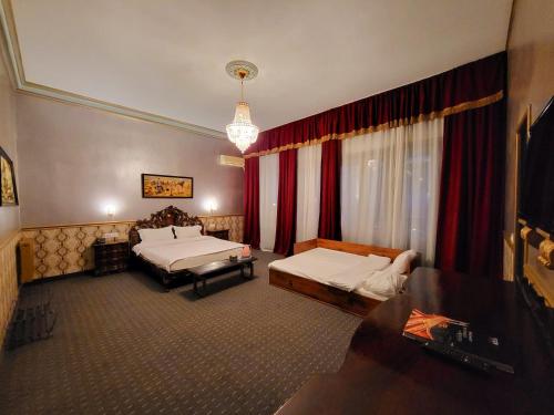 a hotel room with two beds and a table at NF Palace Old City Bucharest in Bucharest