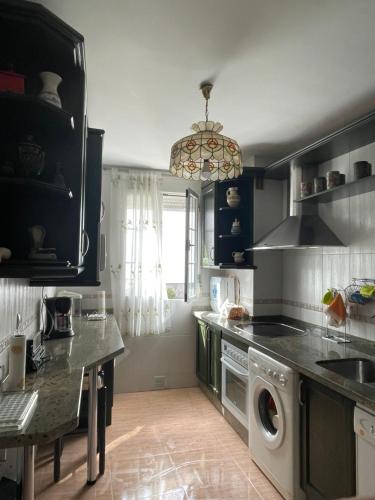 una cocina con lavadora y secadora. en Casa de la Cañada - piso completo, en Carchelejo
