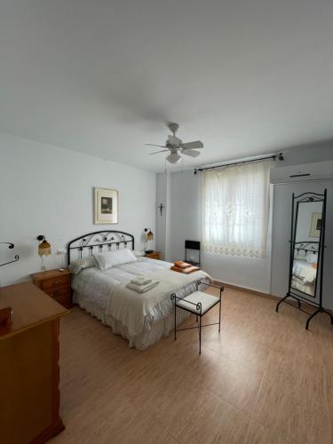 um quarto com uma cama e uma ventoinha de tecto em Casa de la Cañada - piso completo em Carchelejo