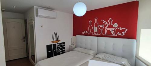 a bedroom with a bed and a painting on the wall at Hostal Pozo in León