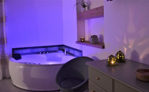 Fioletowa łazienka z wanną i krzesłem w obiekcie The Court Suites & Spa w mieście Tarent