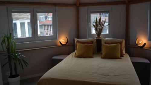 a bedroom with a large bed with two windows at THE ROOFTOP - a trendy new apartment with airconditioning, large terrace & free parking in Ostend