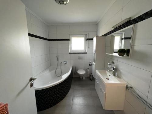 a bathroom with a tub and a toilet and a sink at Prime Host Lovely Apartment in Karlsruhe