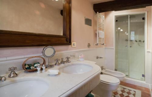 a bathroom with a sink and a toilet and a mirror at Castello di Spaltenna Exclusive Resort & Spa in Gaiole in Chianti