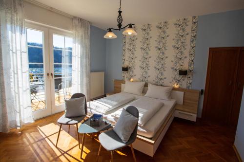 a bedroom with a bed and two chairs and a window at Der Weinladen in Kröv