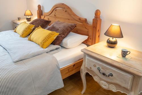 Un dormitorio con una cama con almohadas amarillas y una mesa. en The Green House, en Mojstrana