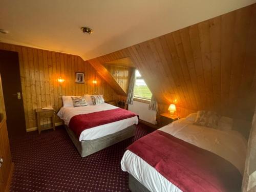 a hotel room with two beds and a window at Ard Einne House Bed & Breakfast in Inis Mor