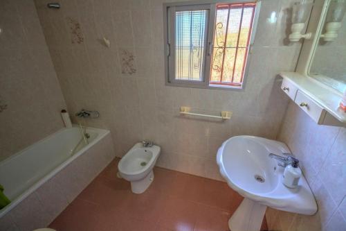 a white bathroom with a sink and a toilet at Vivienda Rural Cortijo de Liche in Arcos de la Frontera