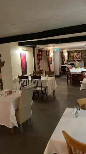 シェプトン・マレットにあるPrestleigh innのダイニングルーム(白いテーブルと椅子、白いテーブルサーチャー付)