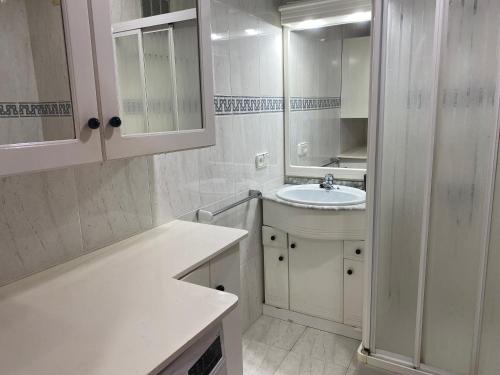 ein weißes Badezimmer mit Waschbecken und Spiegel in der Unterkunft Apartamento 19th floor & sea view in Alicante