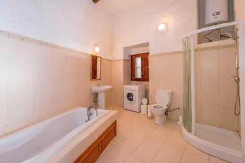 a bathroom with a tub and a toilet and a sink at Farmhouse Cala2 in Qala