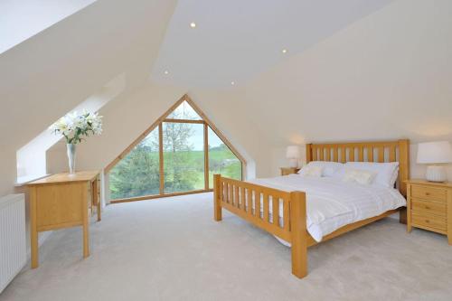 um quarto com uma cama e uma grande janela em Stunning Country House with beautiful views em Inverurie