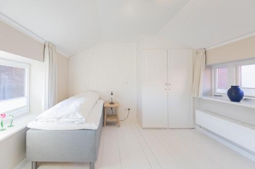 Hugin في هوسوم: غرفة نوم بيضاء مع سرير ونافذة