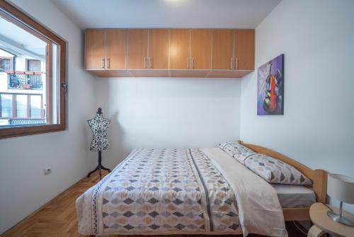 1 dormitorio con cama y ventana en Apartman J&I en Kotor
