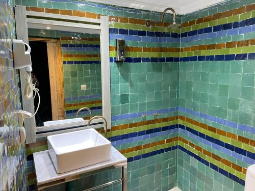 a bathroom with a sink and a mirror at Mama Souiri Hotel in Essaouira