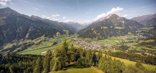 a valley in the mountains with a town and trees at Bergsuite Pfaffenebner in Matrei in Osttirol