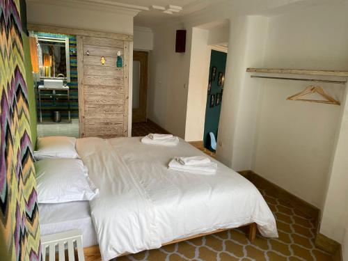 a bedroom with two beds with white sheets at Mama Souiri Hotel in Essaouira