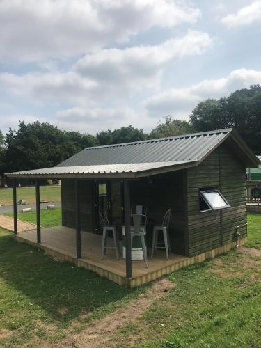 a cabin with a deck and a metal roof at The Gulliver's Hotel in Warrington