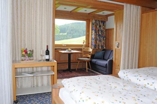 1 dormitorio con 1 cama, 1 silla y 1 ventana en Gästehaus Nigg, en Eisenberg
