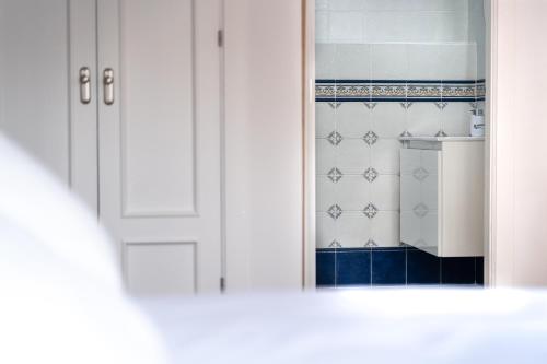 otwarte drzwi do kuchni z niebiesko-białymi płytkami w obiekcie Duplex 8 Caños w mieście Ronda