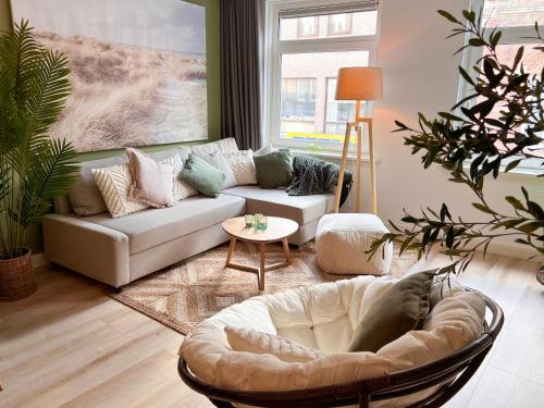 ein Wohnzimmer mit einem Sofa und einem Stuhl in der Unterkunft Abbey Green Lodge in Breda