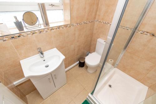 a bathroom with a toilet and a sink and a shower at Fantastic 3 Bedroom House *Free Parking* in Wolverhampton
