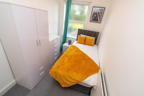 um pequeno quarto com uma cama e uma janela em Fantastic 3 Bedroom House *Free Parking* em Wolverhampton