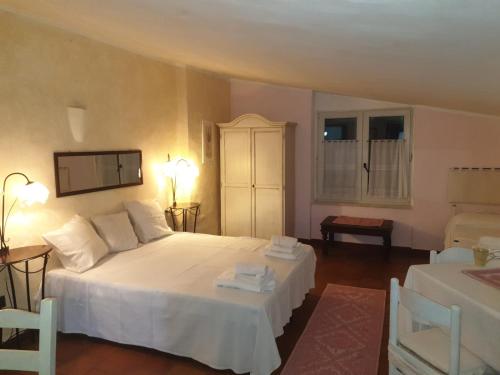 a bedroom with a large white bed and two chairs at Angelo e Arcangela in Telti