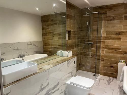 Un baño con lavabo, inodoro y ducha. en WEST END -Stunning, 2 bedroom, main door flat with private parking, en Glasgow