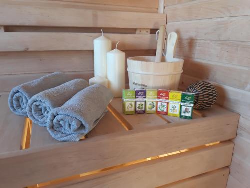 a wooden shelf with towels and candles on it at Siedlisko Podlasie in Kuraszewo