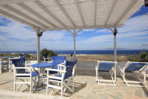 a group of chairs and tables under a pergola at Unique Galini Oia - Adults Only in Oia