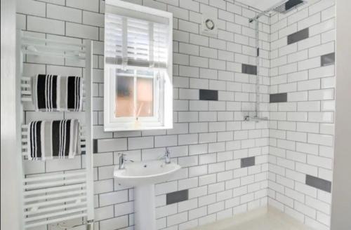 a white bathroom with a sink and a mirror at Miltons Holiday Let in Grimston