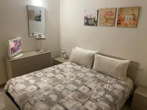 a bedroom with a bed and two pictures on the wall at Lo Scalo Apartment in Molfetta
