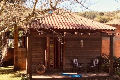 a small cabin with two chairs and a table at Pousada Ananda in Osório