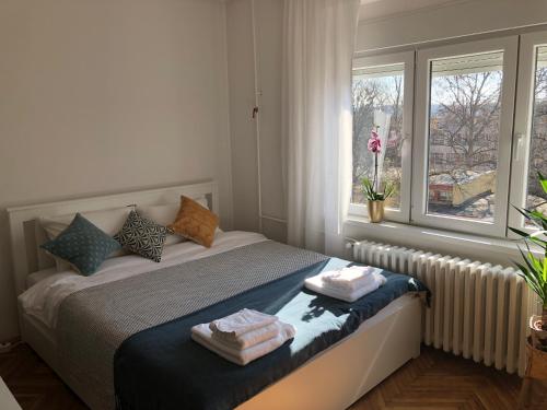 een slaapkamer met een bed met handdoeken erop bij Casa Lusi in Novi Sad