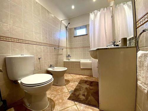 a bathroom with a toilet and a sink and a tub at Palma's Place Casanova Villa #WIFI#HEATEDPOOL#RELAX in Faro