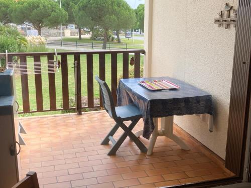 uma mesa e uma cadeira numa varanda em Appartement location Vaux sur Mer plage à partir de 4 nuits minimum em Vaux-sur-Mer