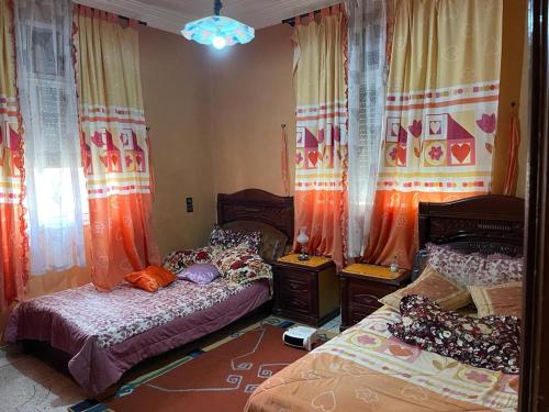 - une chambre avec 2 lits jumeaux et des rideaux dans l'établissement Cozy Home in Azrou, à Azrou