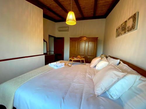 a large white bed in a bedroom with a lamp at Palma's Place Casanova Villa #WIFI#HEATEDPOOL#RELAX in Faro
