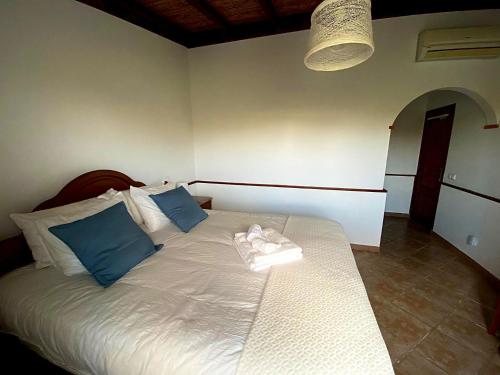 a bedroom with a bed with blue and white pillows at Palma's Place Casanova Villa #WIFI#HEATEDPOOL#RELAX in Faro